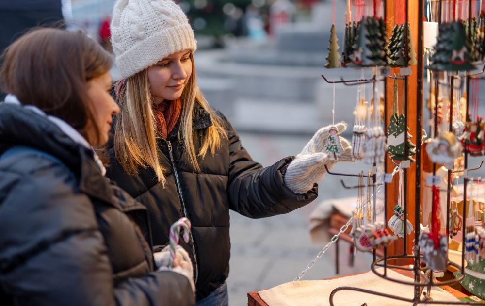 girls at christmas market vendor stand